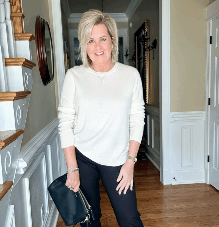 Tania wearing a black and white outfit with a black crossbody travel bag.